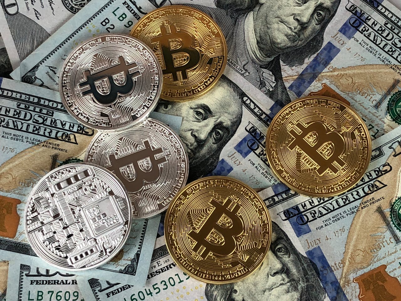 Hands typing on a laptop with cryptocurrency charts and smartphone display in view, focusing on digital finance.